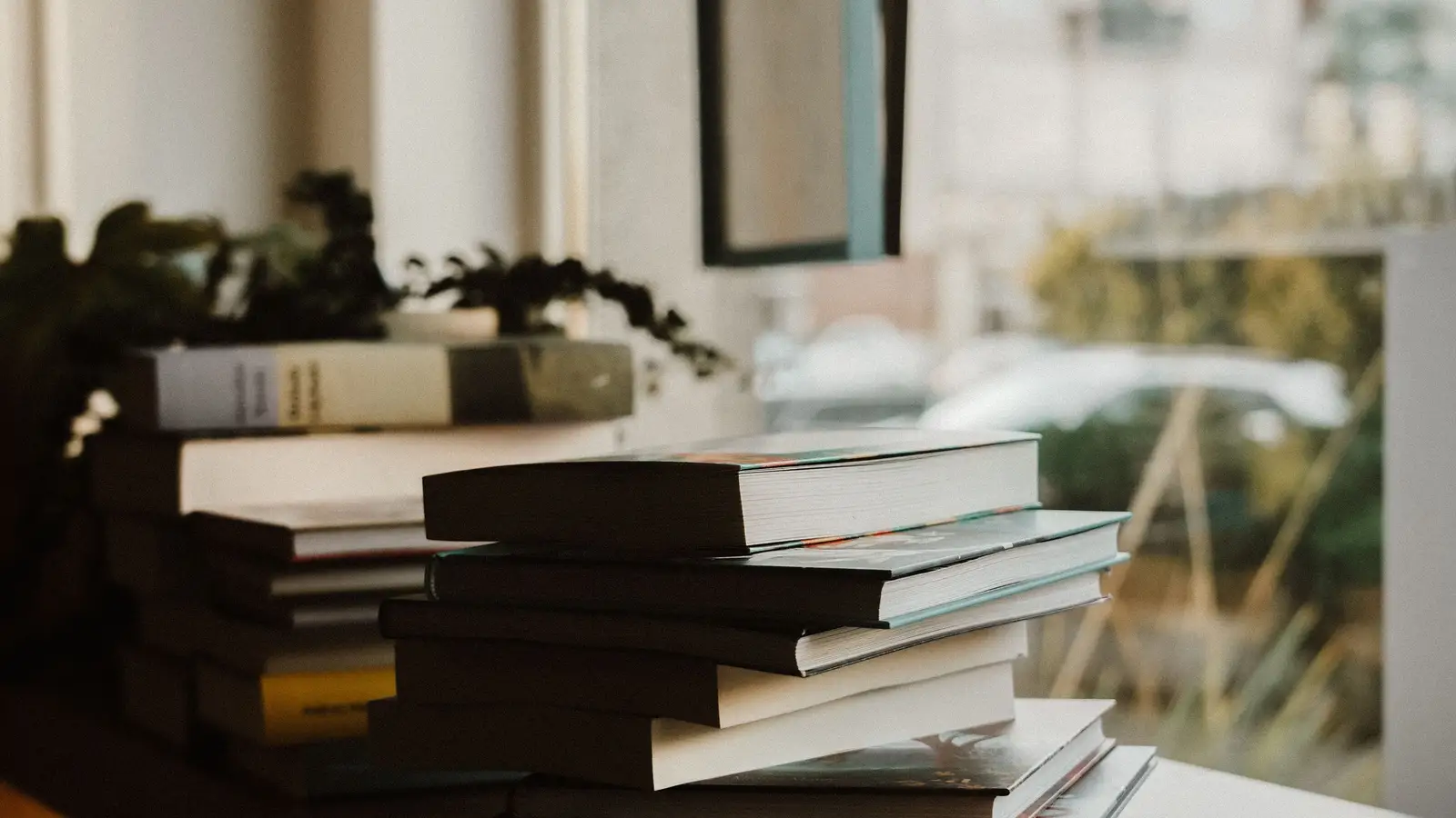 Books stacked on a desk — illustrative photography